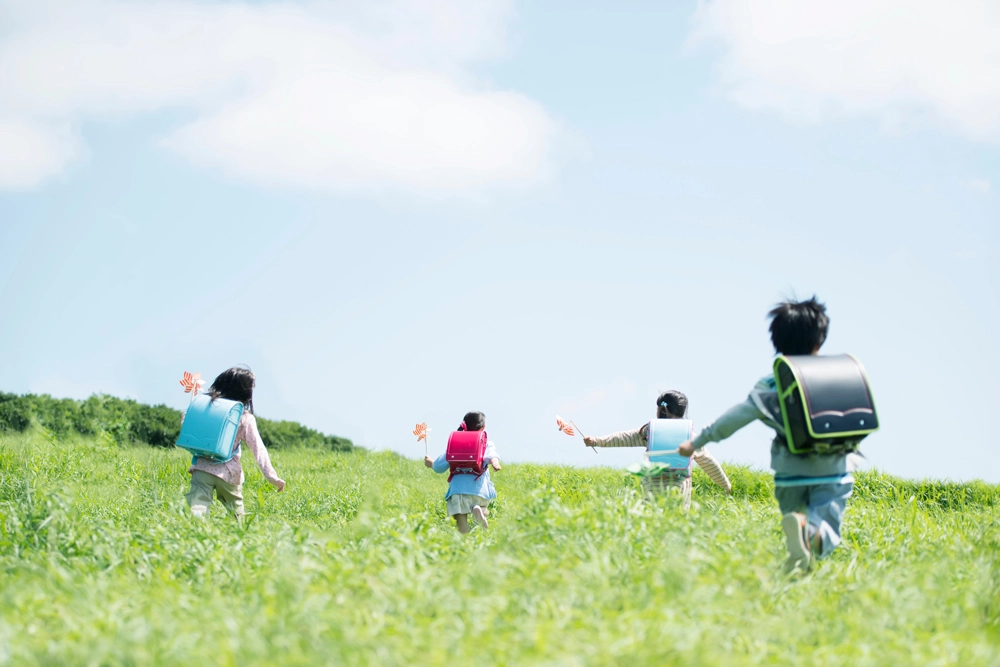 草原を走る４人の小学生